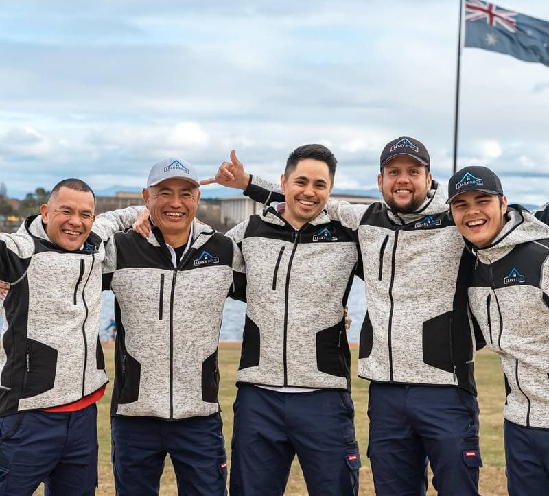 Leaky Roof crew in matching uniforms with Australian flag in Canberra